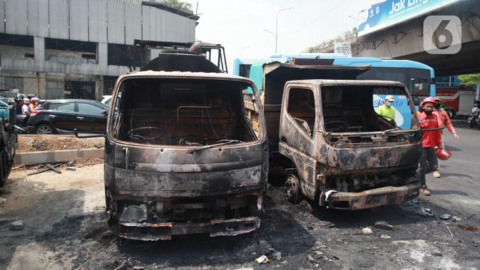 Kondisi sejumlah mobil proyek yang hangus terbakar saat unjuk rasa menolak pengesahan Undang-Undang Cipta Kerja di kawasan Senen, Jakarta, Jumat (9/10/2020). Unjuk rasa tersebut berakhir ricuh dan mengakibatkan sejumlah fasilitas umum rusak. (Liputan6.com/Angga Yuniar)