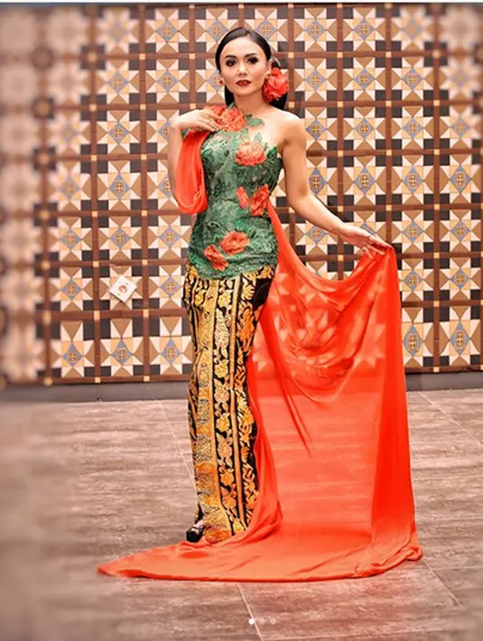 Foto hitam putih Yuni sambil memegang buku dan bolpoin. Yuni tampil anggun dan cantik dengan busana Jawa yang dikenakan. Sanggul di kepala dan selendang di melingkar. (Instagram/yunishara36)