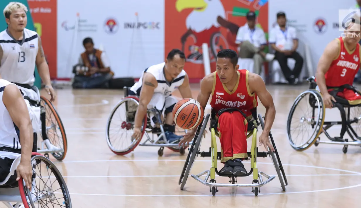 Pebasket difabel Indonesia, Danu Kuswantoro (tengah) membawa bola saat melawan Thailand, Ameen Ha-Rai pada laga Indonesia Para Games Invitational Tournament 2018 di Hall A GBK, Jakarta, Senin (2/7). Indonesia kalah 35-58. (Liputan6.com/Helmi Fithriansyah)