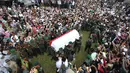 Personil TNI menggotong jenazah tokoh PBNU KH Hasyim Muzadi jelang pemakaman di Ponpes Al-Hikam, Kukusan, Beji, Depok, Kamis (16/3). Jenazah KH Hasyim Muzadi dimakamkan secara militer dengan iringan lantunan tahlil. (Liputan6.com/Immanuel Antonius)
