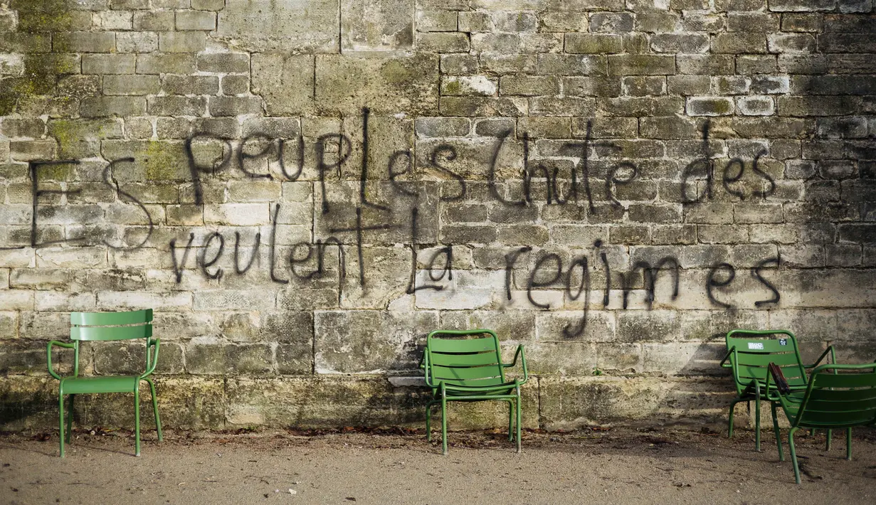 Grafiti bertuliskan 'rakyat menginginkan jatuhnya sistem' tertulis pada dinding di Kebun Tuileries, Paris, Prancis, Minggu (2/12). Protes atas kenaikan pajak bahan bakar telah tumbuh menjadi kemarahan umum. (AP Photo/Kamil Zihnioglu)