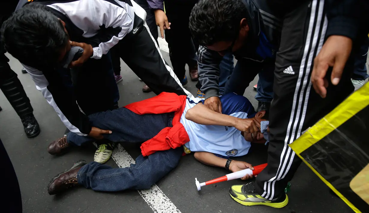Seorang guru sekolah negeri tergeletak setelah tertembak peluru karet saat bentrokan dengan polisi di Lima, Peru, (24/8). Guru sekolah dari beberapa bagian negara Amerika Latin telah melakukan pemogokan selama 70 hari terakhir. (AP Photo / Martin Mejia)