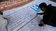 Peserta menandatangani spanduk “Deklarasi Hidup Tanpa Hoax dan Fitnah di kawasan Bundaran HI, Jakarta, Minggu (29/1). Aksi itu untuk meningkatkan kewaspadaan terhadap berita hoax dan fitnah terutama menjelang Pilkada Serentak. (Liputan6.com/Faizal Fanani)