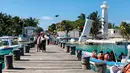 Turis berjalan di sepanjang dermaga di Puerto Morelos, negara bagian Quintana Roo, Meksiko (14/2). Puerto Morelos dibagi oleh jalan raya dan rawa bakau menjadi tiga bagian. (AFP Photo/Daniel Slim)
