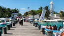 Turis berjalan di sepanjang dermaga di Puerto Morelos, negara bagian Quintana Roo, Meksiko (14/2). Puerto Morelos dibagi oleh jalan raya dan rawa bakau menjadi tiga bagian. (AFP Photo/Daniel Slim)