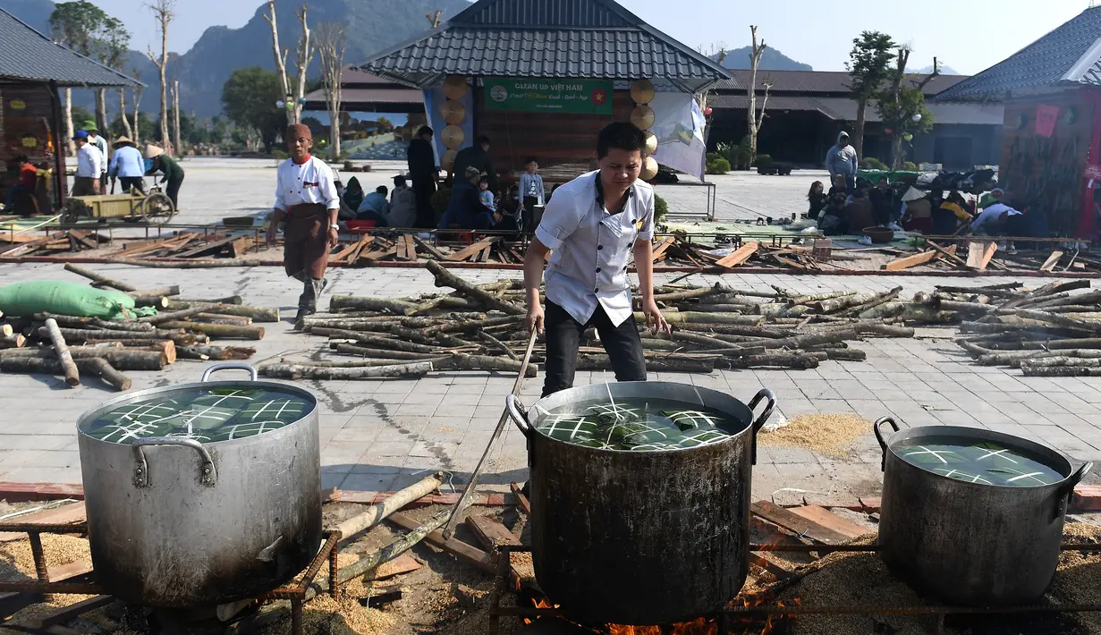 Seorang pria menyiapkan "Banh Chung" atau kue beras tradisional Vietnam untuk amal, menjelang Tahun Baru Imlek atau festival Tet di Pagoda Tam Chuc di provinsi Ha Nam (7/1/2023). Banh Chung adalah kelezatan khas Vietnam yang terbuat dari ketan, daging babi, dan kacang hijau yang dibungkus dengan daun pisang dan dimasak selama 10 jam. (AFP/Nhac Nguyen)