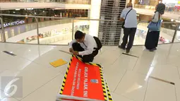 Petugas menyiapkan stiker penunggak pajak yang akan ditempel di wahana bermain anak di pusat perbelanjaan di kawasan Senayan, Jakarta, Senin (5/9). Pemasangan stiker dilakukan Dinas Pelayanan Pajak DKI lantaran menunggak pajak. (Liputan6.com/Angga Yuniar)