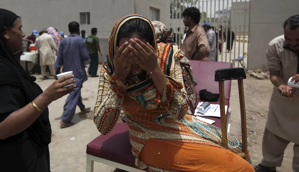 Seorang wanita membasahi wajahnya ketika cuaca panas yang ekstrem di Karachi, Pakistan, (23/6/2015). Gelombang panas yang telah menewaskan lebih dari 400 jiwa di kota selatan Pakistan. (REUTERS/Akhtar Soomro)