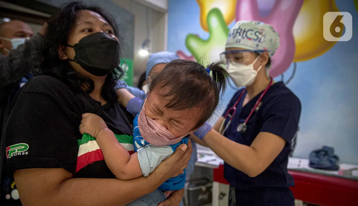 Petugas memeriksa kesehatan serta imunisasi pasien anak di RSIA Bunda, Jakarta, Jumat (18/3/2022). Pemeriksaan dilakukan drive thru guna memberi rasa aman orangtua, khususnya ibu yang ingin melaksanakan imunisasi serta pemeriksaan nonpenyakit di tengah pandemi COVID-19. (Liputan6.com/Faizal Fanani)