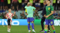 Momen itu berawal dari seorang bocah yang tiba-tiba brelari mendatangi Neymar yang sedang dihibur oleh Dani Alves. Bocah yang diketahui merupakan anak dari Ivan Perisic itu sempat dihentikan official Brasil. (AFP/Adrian Dennis)