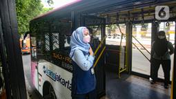 Seorang petugas layanan bus Transjakarta khusus wanita menunggu penumpangg di kawasan Pasar Baru, Jakarta, Rabu (27/7/2022). Pelayanan bus pink ini merupakan salah satu upaya Transjakarta ikut menangani masalah pelecehan dalam transportasi publik. (Liputan6.com/Faizal Fanani)