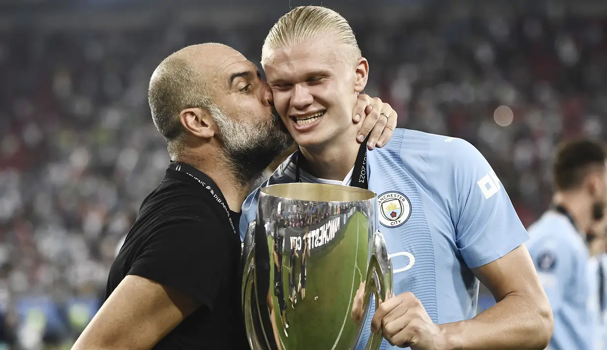 Pelatih Manchester City,  Pep Guardiola, mencium Erling Haaland saat perayaan juara UEFA Super Cup 2023 di Stadion Georgios Karaiskakis, Kamis (17/8/2023). Laga Piala Super Eropa kali ini berakhir imbang 1-1 dalam 90 menit, Man City menang 5-4 di babak adu penalti. (AFP/Spyros Bakalis)