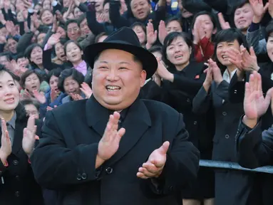 Pemimpin Korea Utara Kim Jong-Un tersenyum sambil bertepuk tangan saat mengunjungi Universitas Guru Pyongyang yang baru direnovasi di Pyongyang (17/1). (KCNA VIA KNS/AFP)