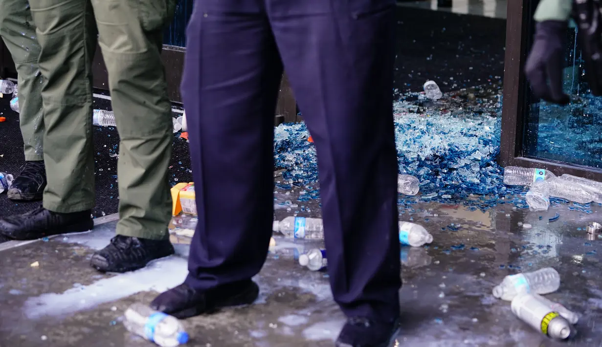 Aparat kepolisian melakukan penjagaan saat aksi protes di kantor pusat CNN di Atlanta, Georgia, Jumat (29/5/2020). Massa yang mengecam kematian George Floyd (46) oleh polisi melakukan vandalisme dan perusakan gedung CNN pusat. (Elijah Nouvelage/Getty Images/AFP)