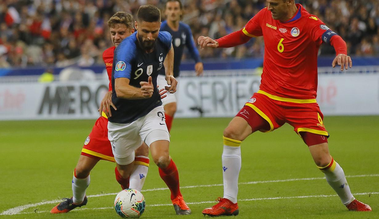 Penyerang Prancis, Olivier Giroud saat dilanggar bek Andorra, Marc Rebes selama pertandingan grup H Kualifikasi Euro 2020 di Stade de France di Saint Denis, Paris (10/9/2019). Prancis menang telak 3-0 atas Andorra. (AP Photo/Michel Euler)