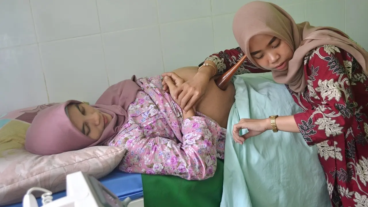 Bidan di Puskesmas Kebasen, Banyumas, memeriksa riwayat kesehatan ibu hamil di aplikasi Saskia Gotak dan memeriksa kesehatan ibu hamil. (Foto: Liputan6.com/Muhamad Ridlo)