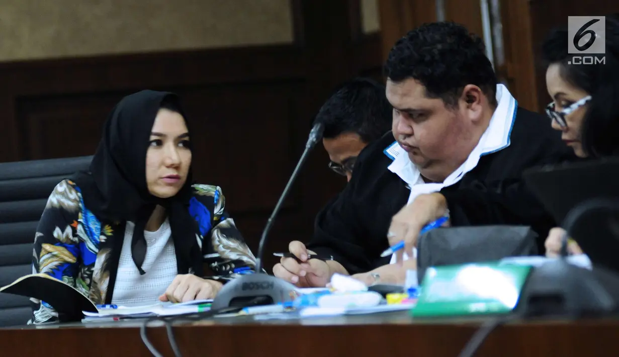 Bupati nonaktif Kutai Kartanegara, Rita Widyasari berbincang dengan penasehat hukumnya pada sidang lanjutan dugaan suap pemberian izin lokasi perkebunan kelapa sawit di Pengadilan Tipikor, Jakarta, Rabu (21/2). (Liputan6.com/Helmi Fithriansyah)