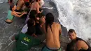 Puluhan wisatawan dan penduduk berusaha untuk membawa Ikan paus yang terdampar itu kembali ke laut, Pantai Popoyo, Nicaragua, Jumat (14/11/2014) (AFP Photo/Inti Ocon)