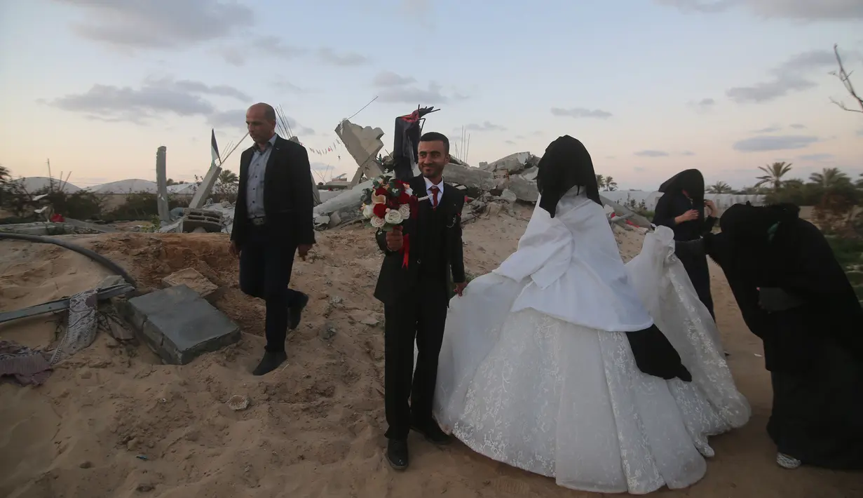 Mohammed Zourab (kedua dari kiri) bersama pengantin perempuannya menggelar pernikahan di atas reruntuhan rumahnya di Kota Khan Younis, Jalur Gaza, 1 Maret 2020. Upacara pernikahan warga Palestina digelar di atas reruntuhan salah satu rumah yang hancur akibat serangan jet Israel. (Xinhua/Khaled Omar)
