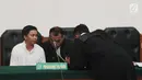 Terdakwa kasus dugaan penipuan dan penggelapan biro perjalanan umrah First Travel, Komisaris First Travel Kiki Hasibuan berbincang dengan kuasa hukunya saat menjalani sidang vonis di PN Depok, Jawa Barat, Rabu (30/5). (Liputan6.com/Herman Zakharia)