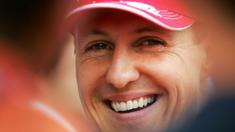 Pembalap Ferrari, Michael Schumacher tersenyum di paddock setelah sesi kualifikasi Formula 1 GP Bahrain di Sirkuit Sakhir pada 11 Maret 2006. (AFP/Loic Venance)