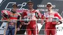 Pebalap Ducati, Danilo Petrucci, bersama Marc Marquez dan Andrea Dovizioso melakukan selebrasi usai menjuarai MotoGP Italia 2019 di Sirkuit Mugello, Minggu (2/6). Petrucci finis pertama dengan catatan waktu 41 menit 33,794 detik. (AP/Antonio Calanni)