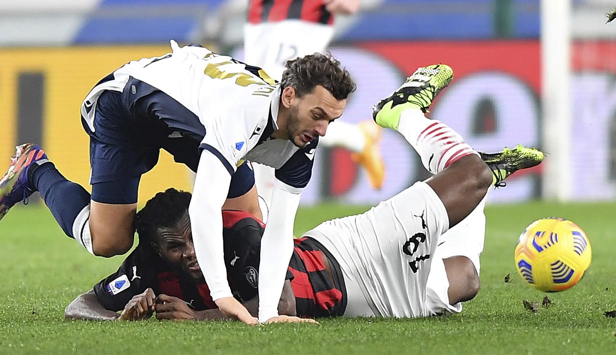 Gelandang AC Milan, Franck Kessie (bawah) dan striker Sampdoria, Manolo Gabbiadini, terjatuh saat perebutan bola dalam laga lanjutan Liga Italia 2020/21 pekan ke-10 di Luigi Ferraris Stadium, Minggu (6/12/2020). AC Milan menang 2-1 atas Sampdoria. (AFP/Andreas Solaro)