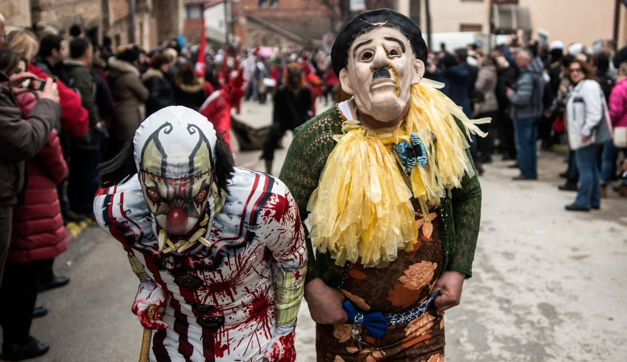 Peserta mengenakan kostum Charlie Chaplin (kanan) saat mengikuti karnaval di desa Vevcani, Macedonia (13/1). Karnaval Vevcani ini diadakan setiap tahun pada malam pesta Santo Basil. (AFP Photo/Robert Atanasovski)