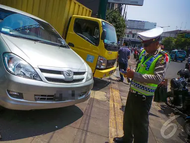 Petugas Dinas Perhubungan dibantu Polantas merazia kendaraan yang parkir liar di kawasan Glodok, Jakarta,(9/9/2014) (Liputan6.com/Faizal Fanani)