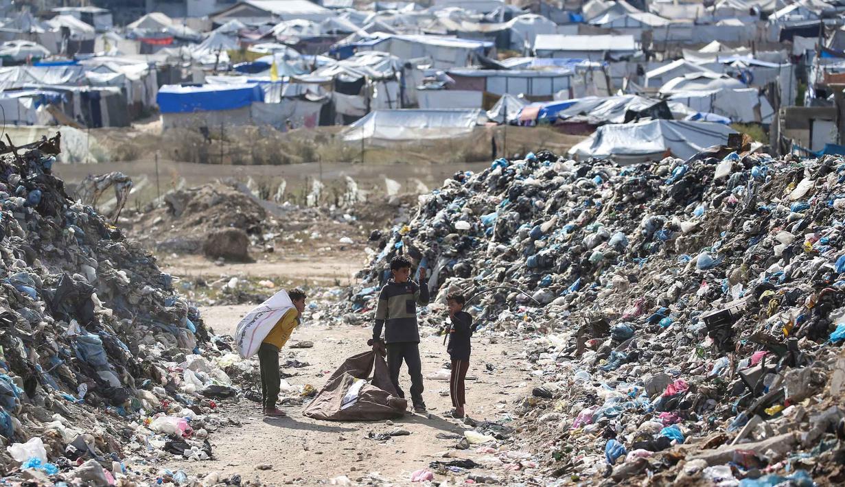 Ribuan keluarga pengungsi masih bertahan hidup di tenda-tenda darurat yang rusak dan tidak layak huni, di tengah kondisi kemanusiaan yang terus memburuk akibat konflik berkepanjangan. Tampak dalam foto, anak-anak memungut sampah di kamp pengungsi Palestina, Nuseirat, Jalur Gaza Tengah pada Kamis 7 Mei 2026. (Eyad Baba/AFP)
