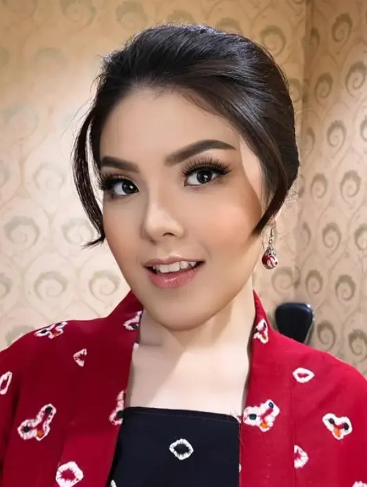 Wajahnya dipoles oleh MUA Sam, dengan gaya makeup on makeup. Tina tampak mengenakan blush on coral dan lipstik nude glossy. Riasan mata yang dibuat “hidup” dengan bulu mata bervolume dan alis mata on fleek. [@tinatoon101]