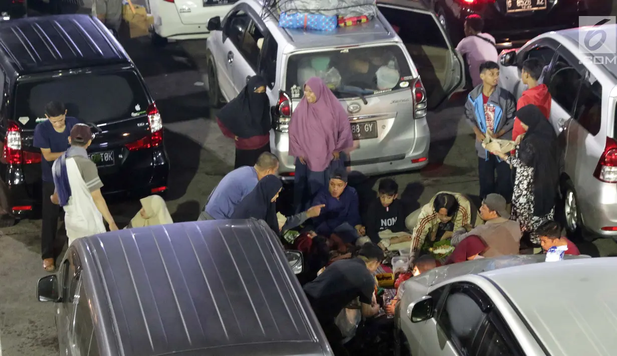 Pemudik makan bersama sambil menanti waktu masuk kapal di Dermaga II Pelabuhan Penyebrangan Merak, Banten, Senin (3/6/2019). Sambil menanti waktu bongkar muat kapal penyebrangan, pemudik memanfaatkan waktu untuk makan bersama. (Liputan6.com/Helmi Fithriansyah)