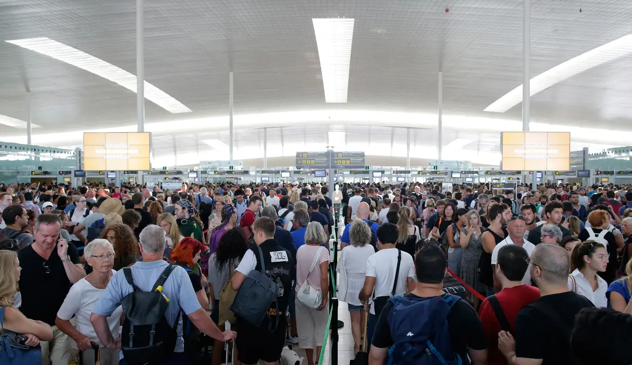 Ribuan penumpang menunggu untuk melewati kontrol keamanan di bandara Barcelona di Prat Llobregat, Spanyol  (4/8). Mogok kerja para staf keamanan bandara yang berlangsung hampir dua jam. (AP Photo / Manu Fernandez)