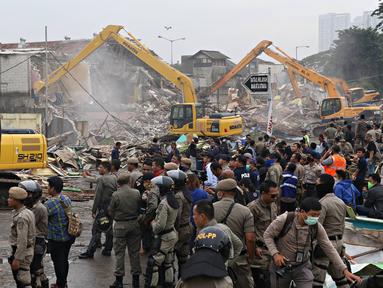 Sejumlah Petugas gabungan saat berjaga di kawasan prostitusi Kalijodo, Jakarta Utara, Senin (29/2). Dalam hitungan jam, puluhan bangunan di kawasan tersebut mulai rata dengan tanah serta menjadi tontonan warga. (Liputan6.com/Immanuel Antonius)