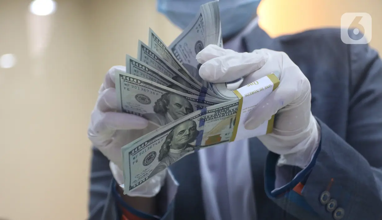Karyawan bank menghitung uang dolar Amerika Serikat (AS) di Jakarta, Senin (2/11/2020). Nilai tukar rupiah pada perdagangan Senin (2/11) sore ditutup melemah 0,1 persen ke level Rp14.640 per dolar AS, dari perdagangan sebelumnya yaitu Rp14.690 per dolar AS. (Liputan6.com/Angga Yuniar)
