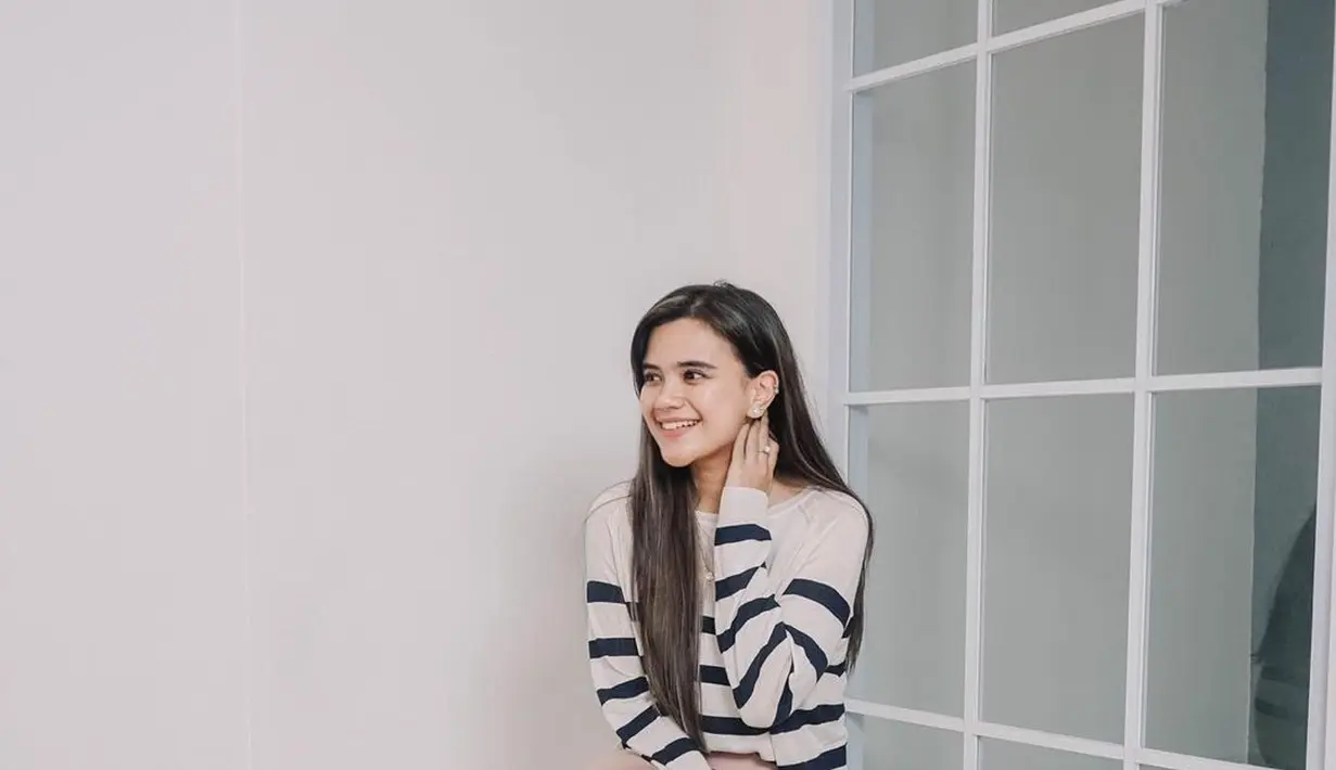 <p>Seperti potret ini, ia tampil manis memadukan striped tee dengan silk skirt dan slip on shoes. (Instagram/audimarissa).</p>