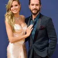 Model senior Heidi Klum dan pacarnya, Tom Kaulitz saat menghadiri Emmy Awards 2018 di Los Angeles, AS, Senin (17/9). Romansa keduanya mulai terkuak ketika mereka kedapatan berciuman di lokasi syuting 'America's Got Talent' Maret lalu. (VALERIE MACON/AFP)