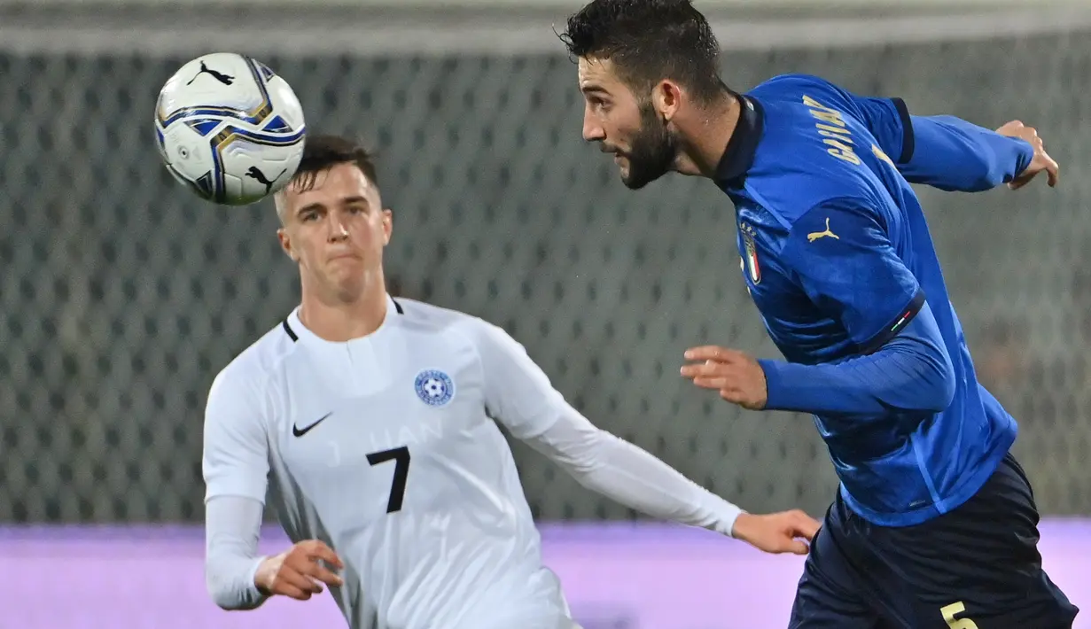 Gelandang Italia, Roberto Gagliardini (kanan) menyundul bola di sebelah gelandang Estonia, Georgi Tunjov dalam laga uji coba internasional di Artemio Franchi, Kamis (12/11/2020) dini hari. Italia tanpa kesulitan mengalahkan Estonia dengan skor 4-0. (Alberto PIZZOLI/AFP)