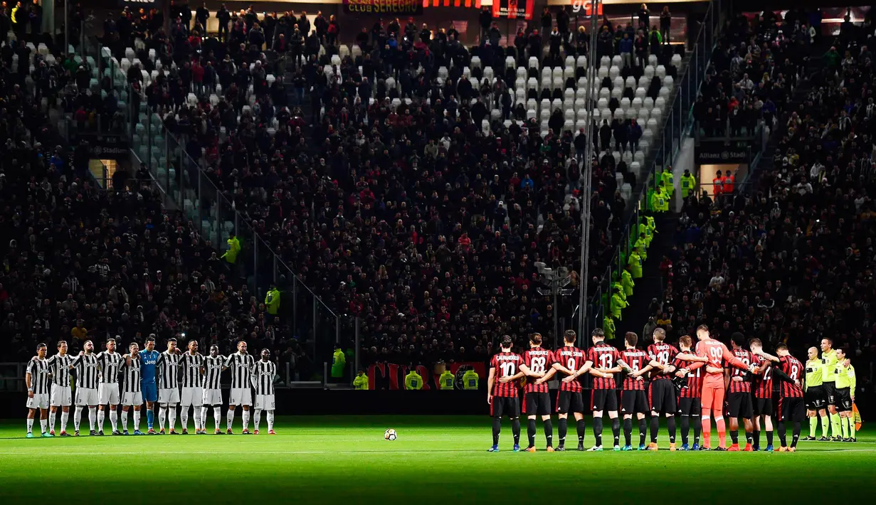 Pemain Juventus dan AC Milan mengheningkan cipta untuk mengenang pelatih Italia Emiliano Mondonico sebelum pertandingan dimulai di Stadion Allianz di Turin (31/3). (Alessandro Di Marco/ANSA via AP)