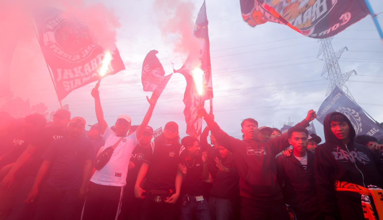Sekadar informasi, laga kedua tim akan berlangsung di di Stadion Gelora Bandung Lautan Api (GBLA), pada Minggu 11 Januari 2025 pukul 15.30 WIB. Tampak dalam foto, pendukung Persija Jakarta atau The Jakmania menyalakan suar saat memenuhi Persija Training Ground, Bojong Sari, Depok, Jawa Barat, Jumat (9/1/2026). (Bola.com/M Iqbal Ichsan)