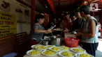 Pengurus Vihara Kim Tek Ie menyiapkan menu makan siang untuk pembeli warung nasi kuning Podjok Halal di Petak Sembilan, Jakarta, Selasa (24/12/2019). Warung Podjok Halal menjual nasi beserta lauk pauk dengan harga Rp 3.000. (merdeka.com/Imam Buhori)
