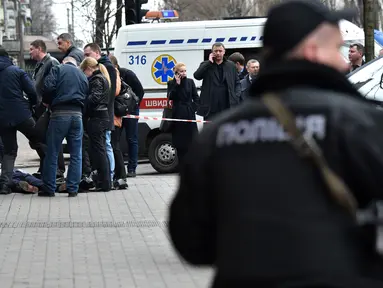 Sejumlah petugas keamanan Ukraina menyelidiki jenazah mantan anggota parlemen Rusia, Denis Voronenkov di Kiev, Ukraina (23/3). Denis Voronenkov tewas seketika setelah ditembak oleh orang tak dikenal. (AFP/Sergei Supinsky)