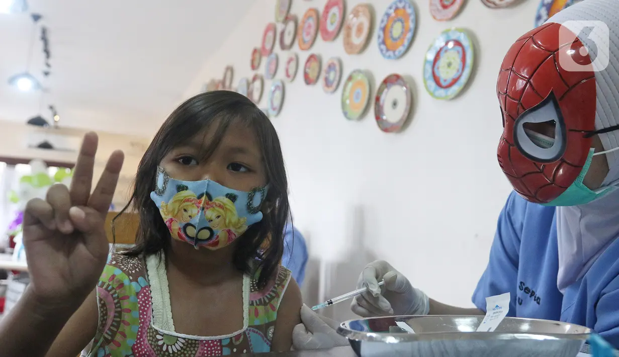 Seorang anak disuntik vaksin covid-19 oleh tenaga kesehatan bertopeng superhero saat vaksinasi anak usia 6-11 tahun di RSIA Tambak, Jakarta, Rabu (22/12/2021). Sebanyak 30 anak mengikuti vaksinasi yang menggunakan vaksin Sinovac tersebut. (Liputan6.com/Herman Zakharia)