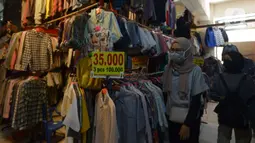 Warga memilih pakaian bekas (Thrifting) di pasar Proyek Senen, Jakarta, Selasa (12/10/2021). Thrifting atau membeli barang bekas layak pakai guna menghemat pengeluaran. (merdeka.com/Imam Buhori)