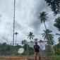 Seorang warga beraktivitas di dekat  infrastruktur jaringan 4G USO yang dikelola XL Axiata di Desa Mekar Jaya, Bunguran Barat, Natuna. (Ist.)