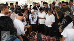 Gubernur Banten, Rano Karno (berpeci) saat membacakan doa pada pemakaman ibunya, Lily Soekarno M Noor di TPU Tanah Kusir Jakarta, Senin (7/12/2015). Ibunda Rano Karno wafat di usia 77 tahun akibat komplikasi penyakit. (Liputan6.com/Helmi Fithriansyah)