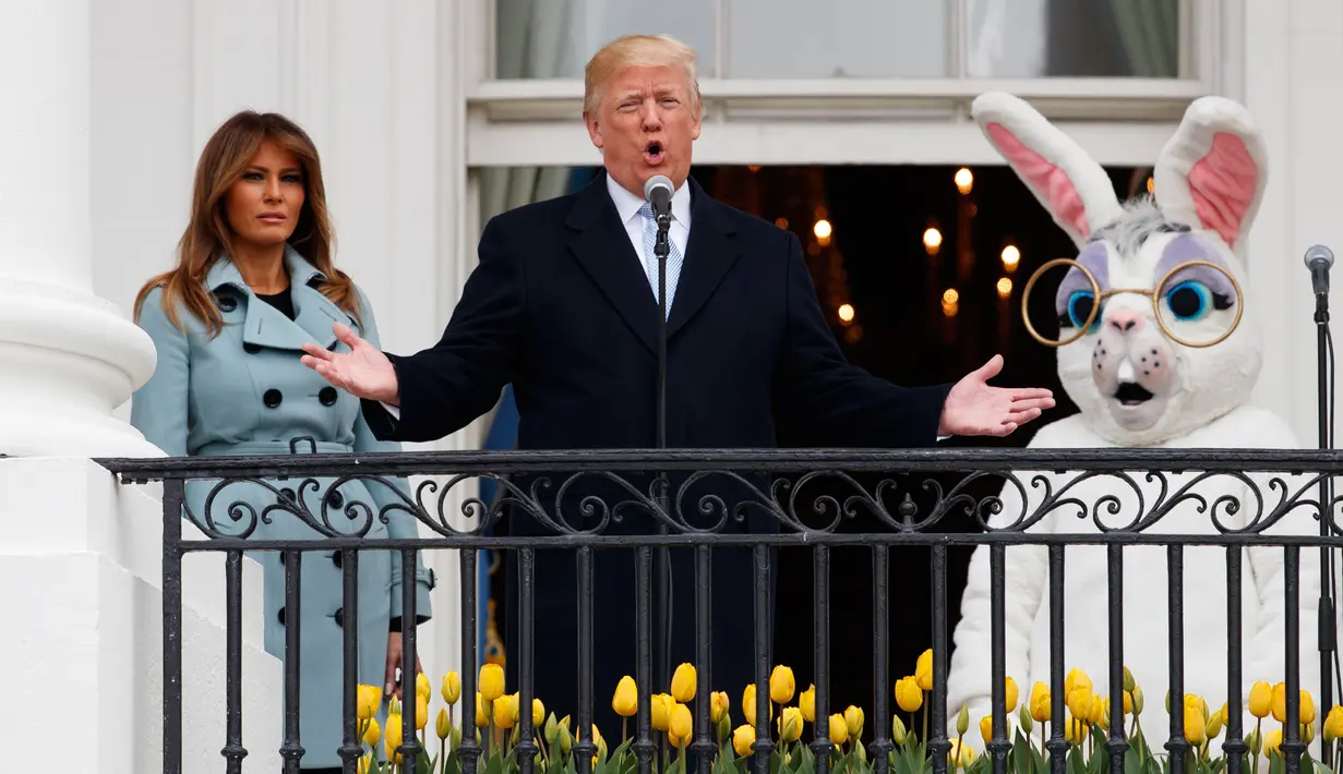 Presiden AS Donald Trump didampingi istirnya Melania Trump dan badut Kelinci Paskah berbicara dari Truman Balcony saat perayaan Easter Egg Roll di Gedung Putih, Washington (4/2). (AP Photo / Carolyn Kaster)