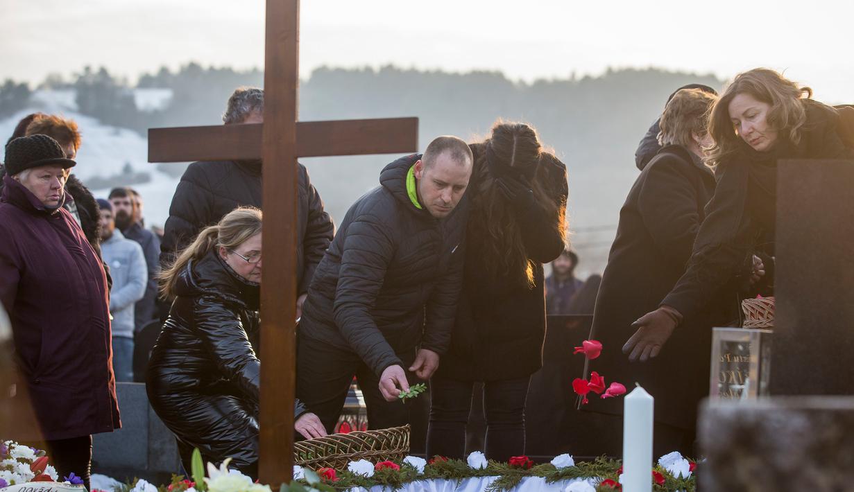 Kerabat dan keluarga menaburkan bunga di pemakaman wartawan investigasi Jan Kuciak di Stiavnik, Slovakia (3/3). Pembunuhan Kuciak terjadi di tengah pembuatan laporan investigasi Kuciak soal kasus dugaan kecurangan pajak. (AP Photo / Bundas Engler)