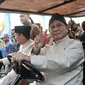 Pasangan capres dan cawapres Prabowo Subianto-Sandiaga Uno menaiki mobil golf sambil menunjukkan salam dua jari saat mengikuti pawai Deklarasi Kampanye Damai di Monas, Minggu (23/9). (Merdeka.com/Iqbal Nugroho)