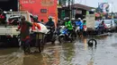 Seorang pria menarik gerobak melintasi jalan berlubang dan tergenang air di Jalan Raya Pabuaran, Citayam, Depok, Rabu (26/2/2020). Kerusakan disebabkan kubangan air yang menggenangi jalan tersebut pada musim hujan  yang melanda Jabodetabek dua bulan terakhir. (merdeka.com/magang/Muhammad Fayyadh)